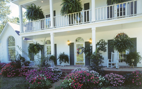 southern plantation style house with amazing flower garden