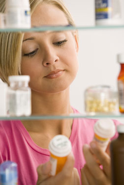 woman checking medicine cabinet