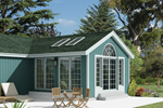Stylish sun room addition has skylights on roof and large arched window above double French doors