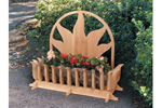 All wood ground level planter has sun shaped motif design on the back