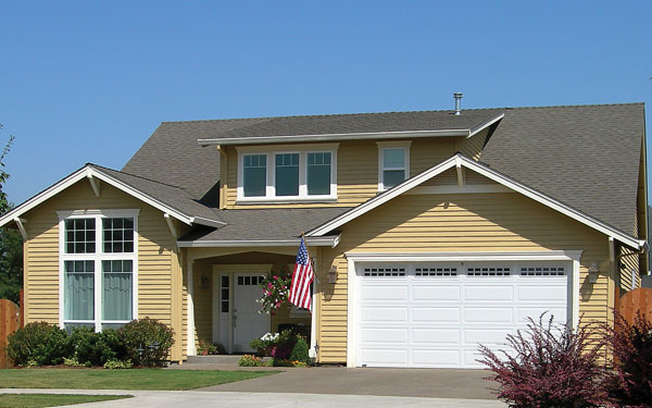 Bungalow style home with American flag hung in front