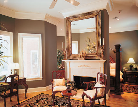 Large square mirror above fireplace in master bedroom