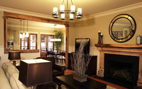 beautiful living room with round mirror above fireplace