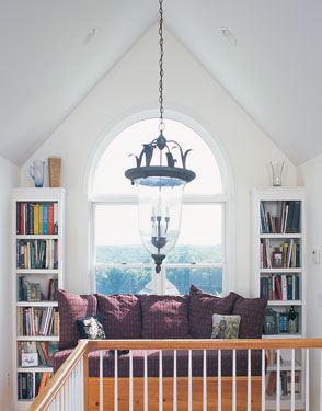 narrow bookcases flanking a large arched window