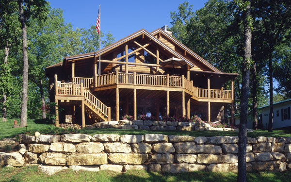 log home with rock landscaping wall