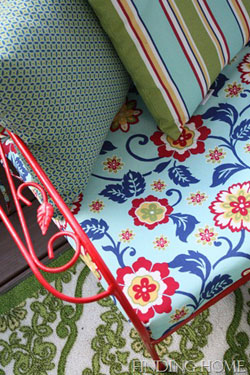 bold patterened chair cushion on red wrought iron chair 