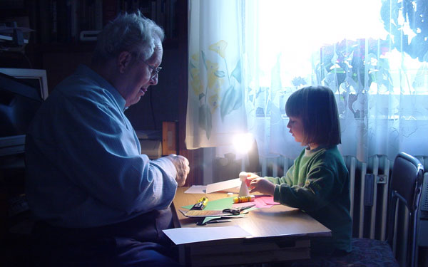 grandpa making crafts with young granddaughter