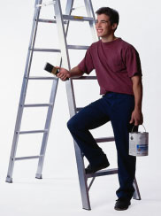 man leaning on ladder with paint can