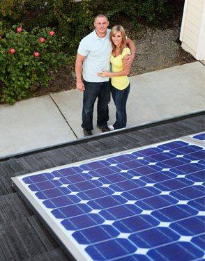 couple by home with solar panels on roof