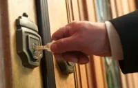 turning lock with key in a front door